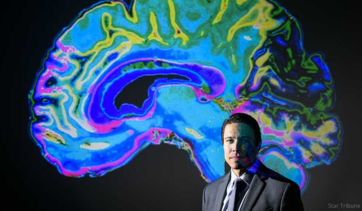 Francis X. Shen, JD, PhD and a colorful brain projection of a brain.