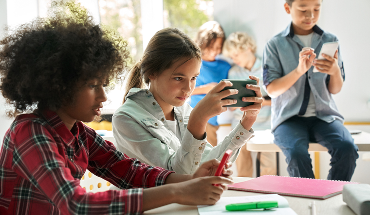 Kids in a classroom all on cell phones.