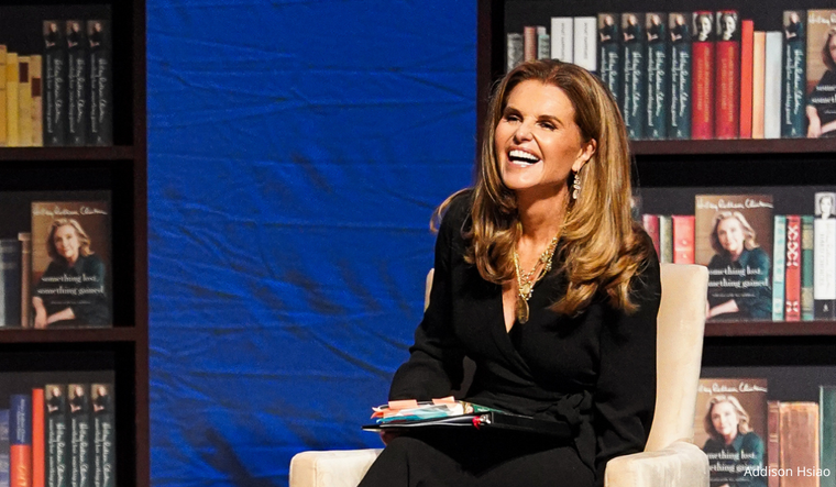 Maria on stage, moderating a Hillary Clinton book event.