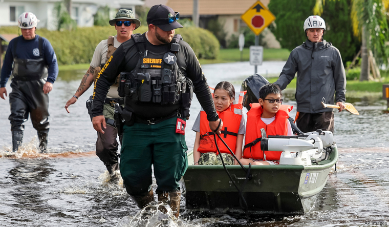 Ruby Bishop and her son Alex are evacuated from her home by Pasco County Fire and Rescue and Sheriff's Office teams.